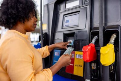 A trucker pays for her fuel with a fuel card at a gas station.