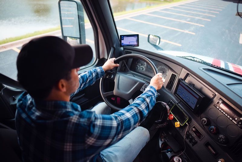 A fleet driver drives his route with a view from inside the semi truck cab.